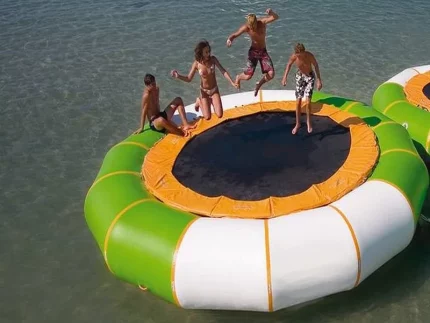 Trampoline gonflable flottant vert et orange, idéal pour jeux aquatiques et loisirs en famille, robuste et fun, à acheter en ligne.